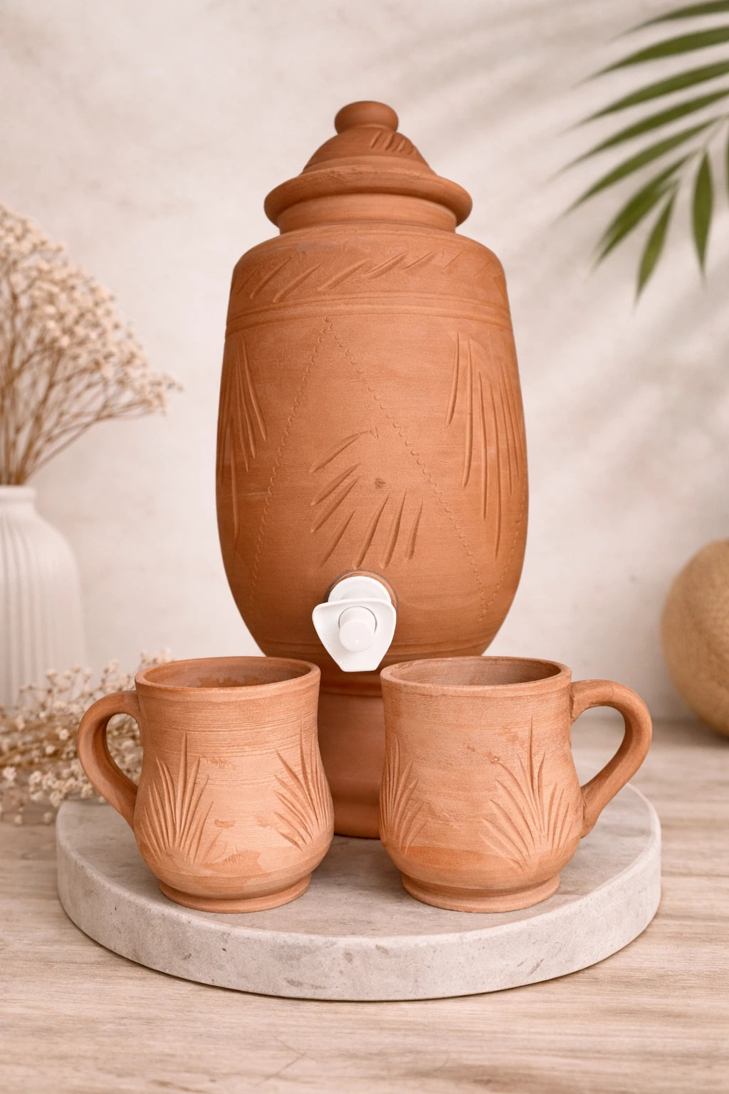 Fontaine en terre cuite artisanale avec deux tasses assorties, poterie faite main au style naturel.